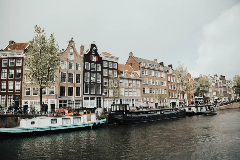 Traditional canal houses and houseboats along a canal in Amsterdam, Netherlands