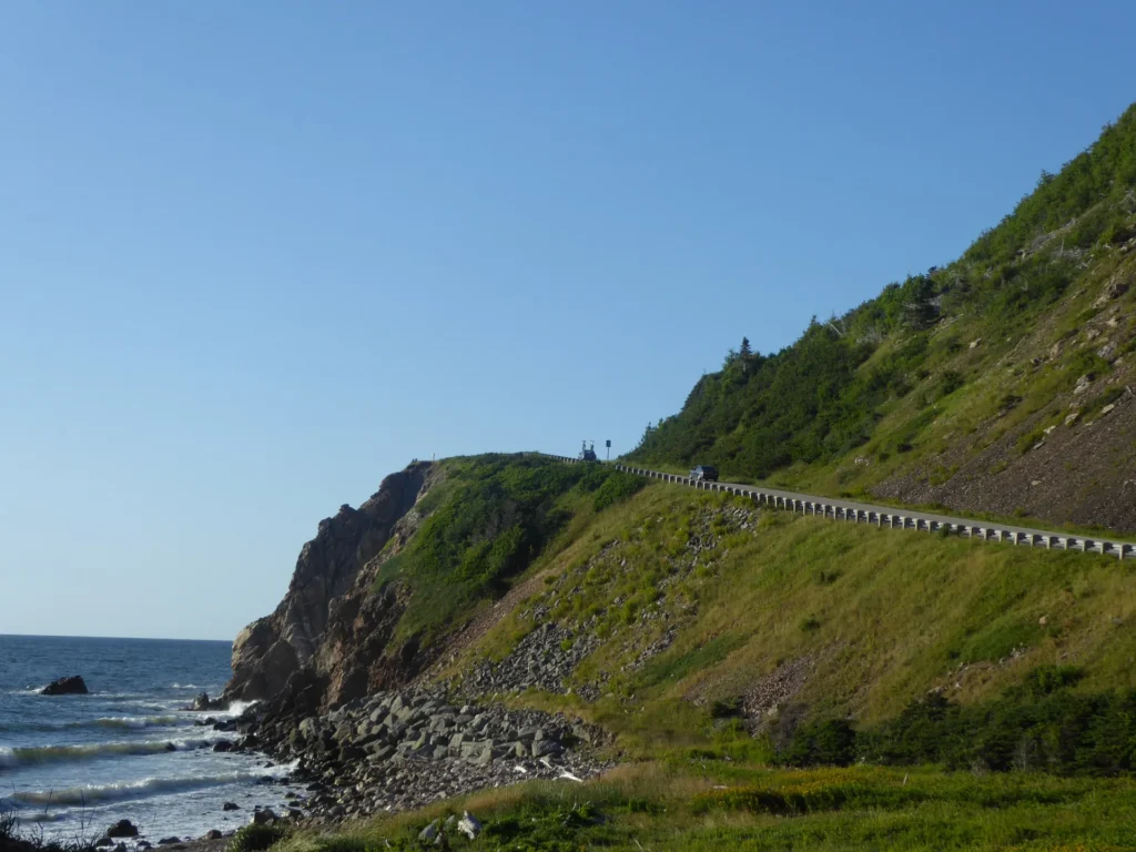 The Cabot Trail road winding along green coastal cliffs in Cape Breton