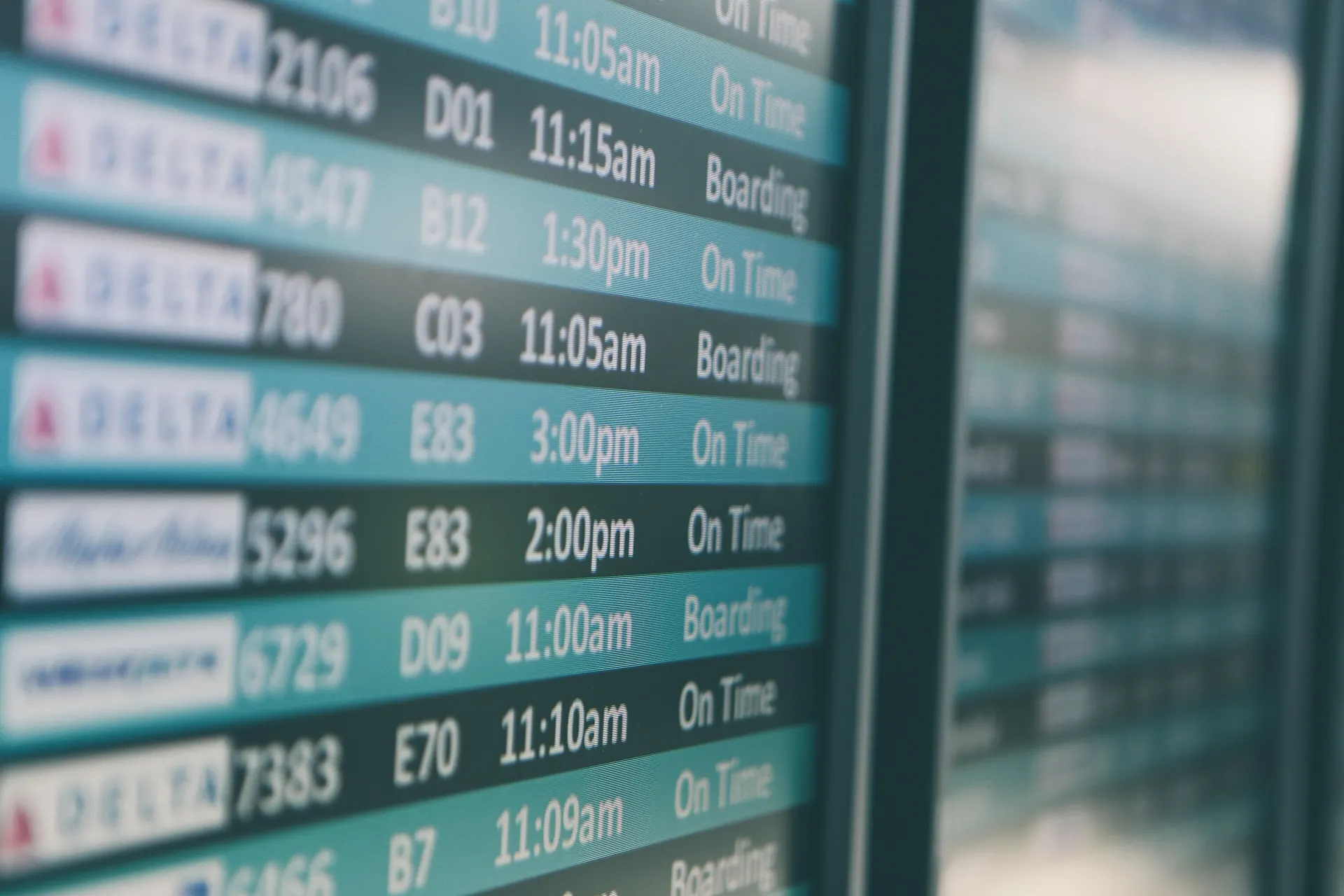 Airport departures board showing flight times and gates
